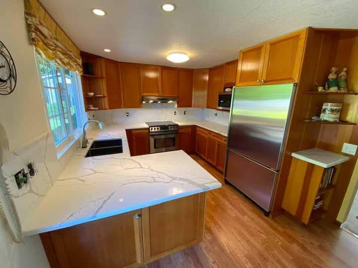 Calacatta quartz U-shaped kitchen counters with honey oak cabinets