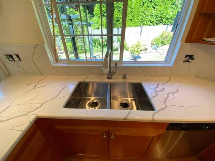 Calacatta quartz counter with undermount sink and garden window view