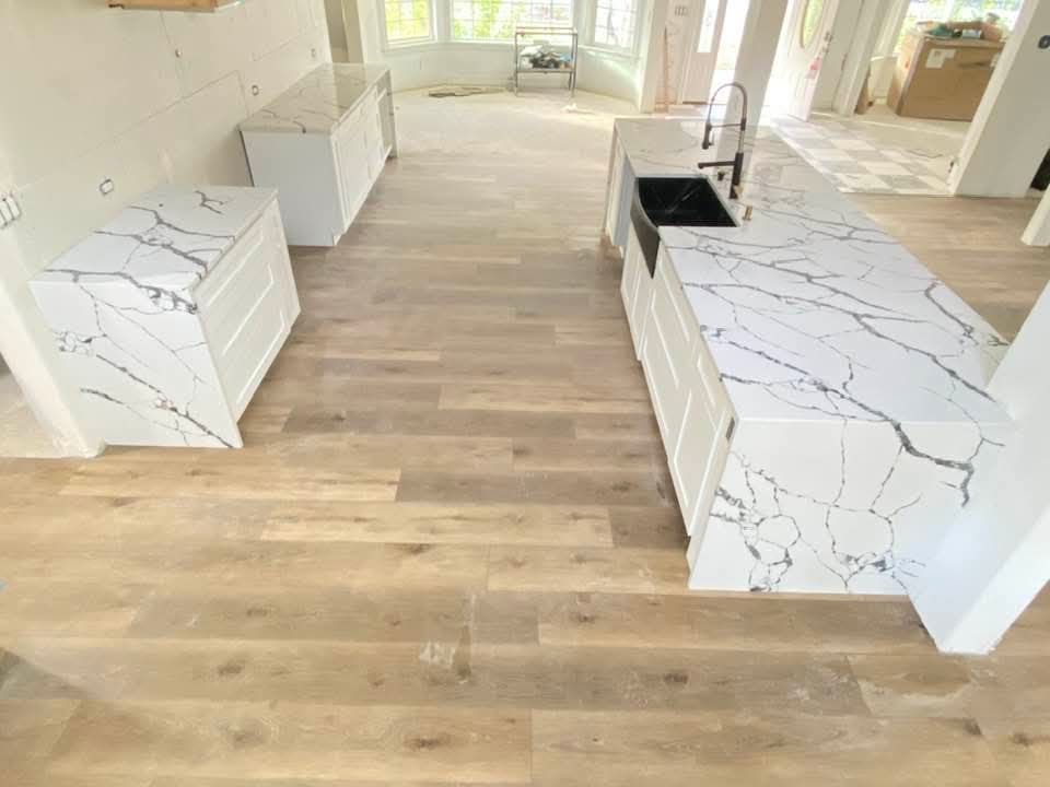 Calacatta quartz double-island kitchen with waterfall edges and black farmhouse sink