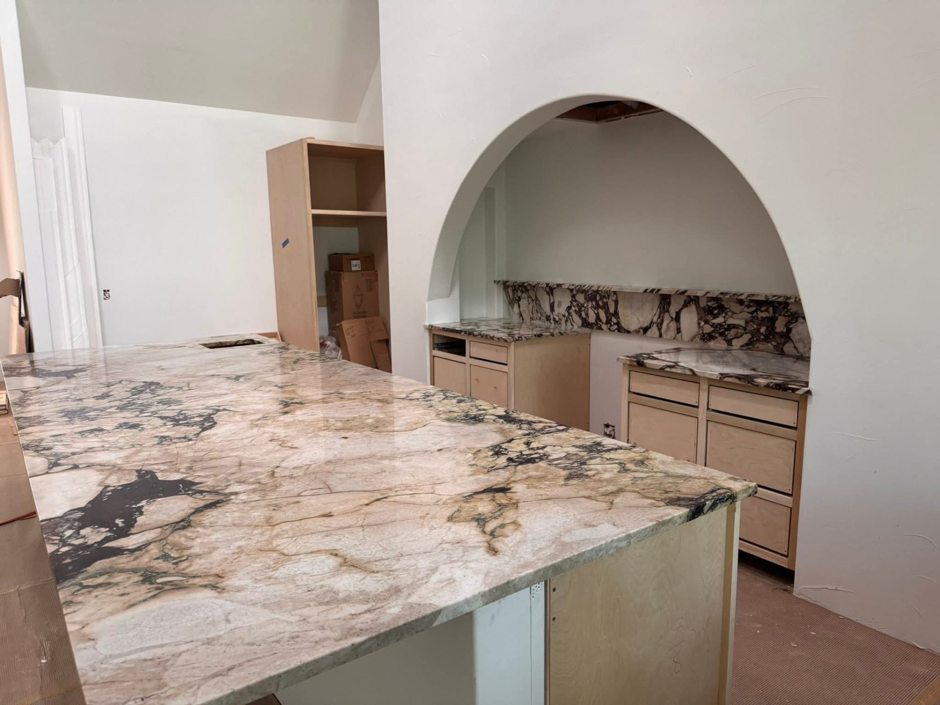 Calacatta Viola marble kitchen island and counters with dramatic purple-gray veining and archway built-in — Seattle area kitchen
