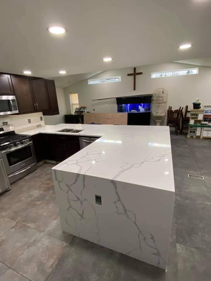 Calacatta quartz waterfall island with dark espresso cabinets and stainless range