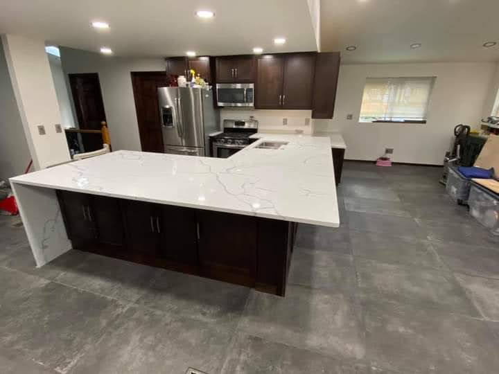 Large Calacatta quartz island with dark espresso cabinets and open layout